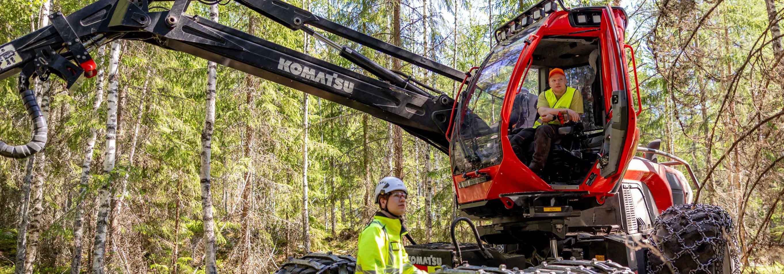 Metsäasiantuntija ja metsäkoneenkuljettaja ensiharvennuksella metsässä.
