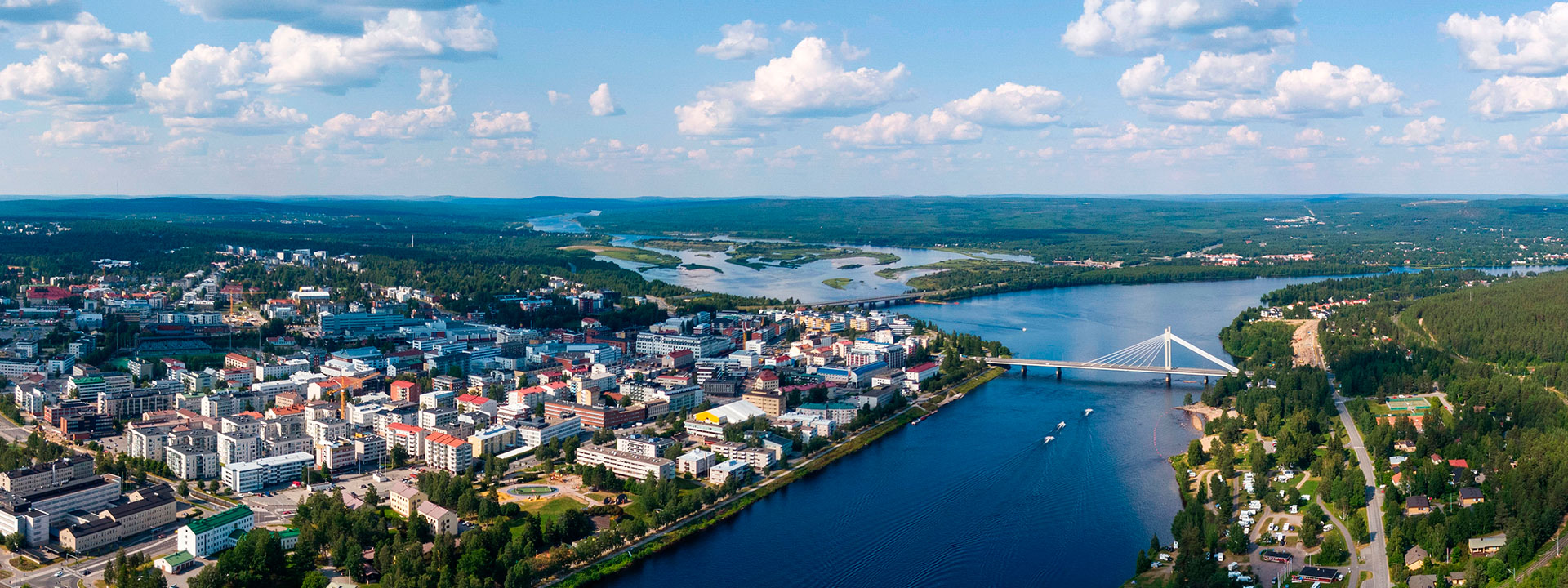 Kaupunki ilmasta käsin katsottuna, joki ja sininen taivas pilven hattaroilla.